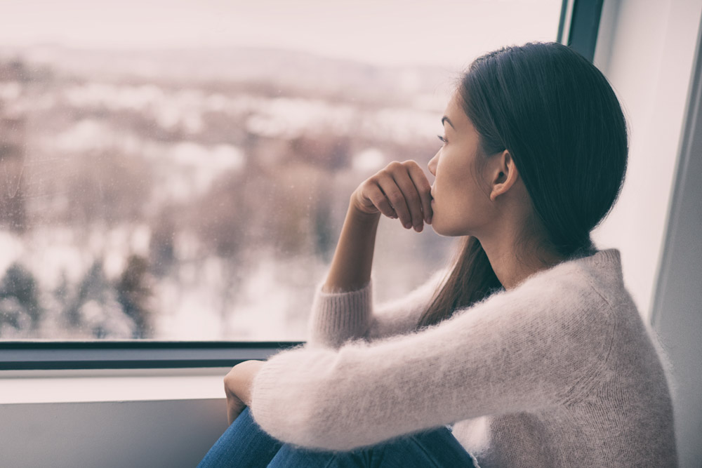woman looking out a window pensively
